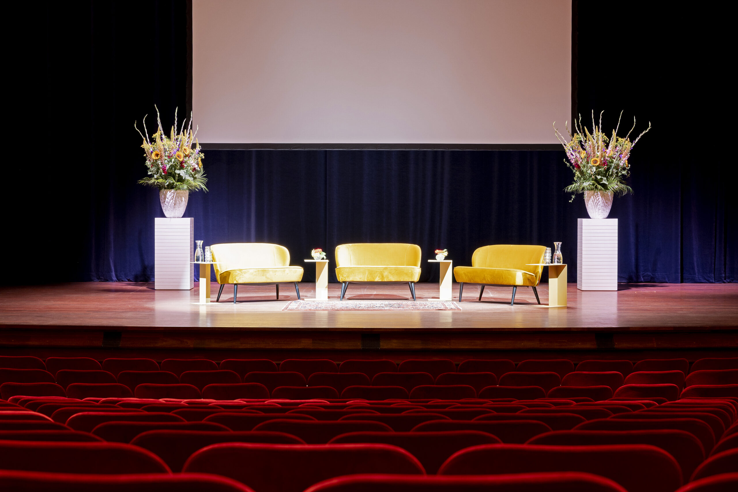 Drie bankjes op het podium in de Grote Zaal van Kunstmin