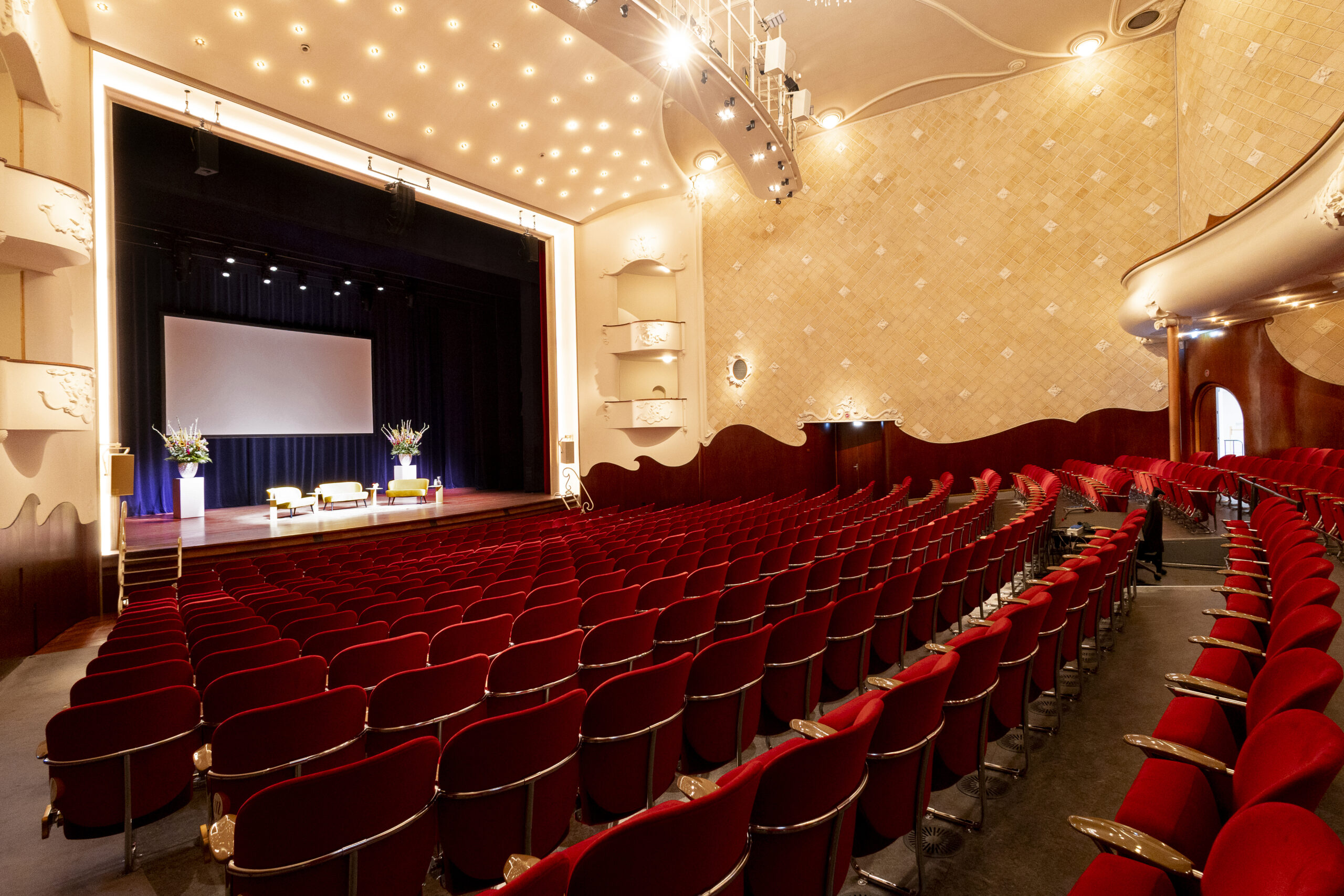 De Grote Zaal van Kunstmin met rode pluchen stoelen
