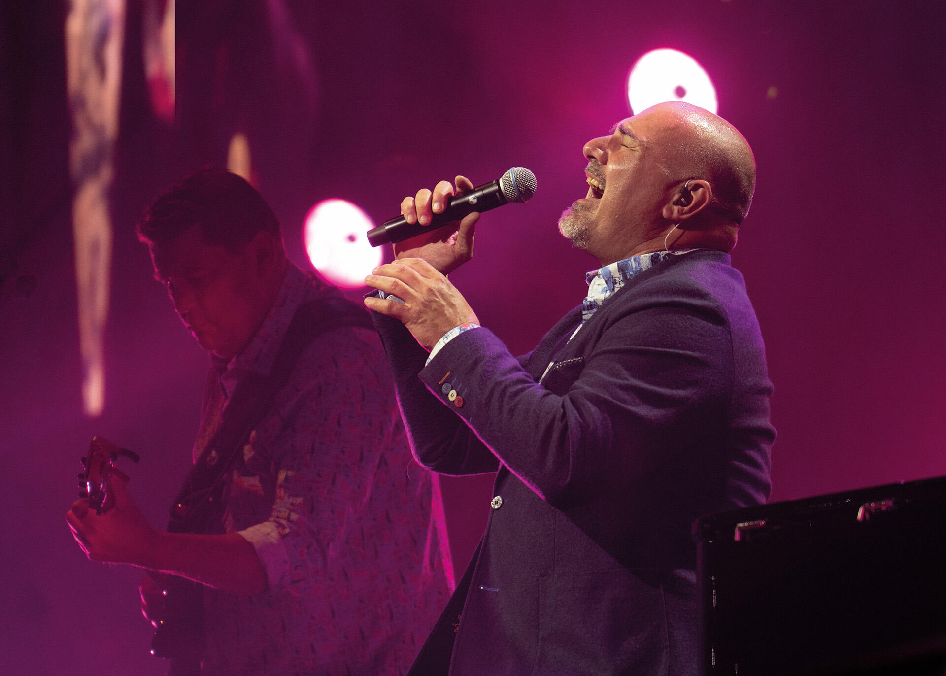 Alexander Broussard zingend met microfoon met paarse achtergrond