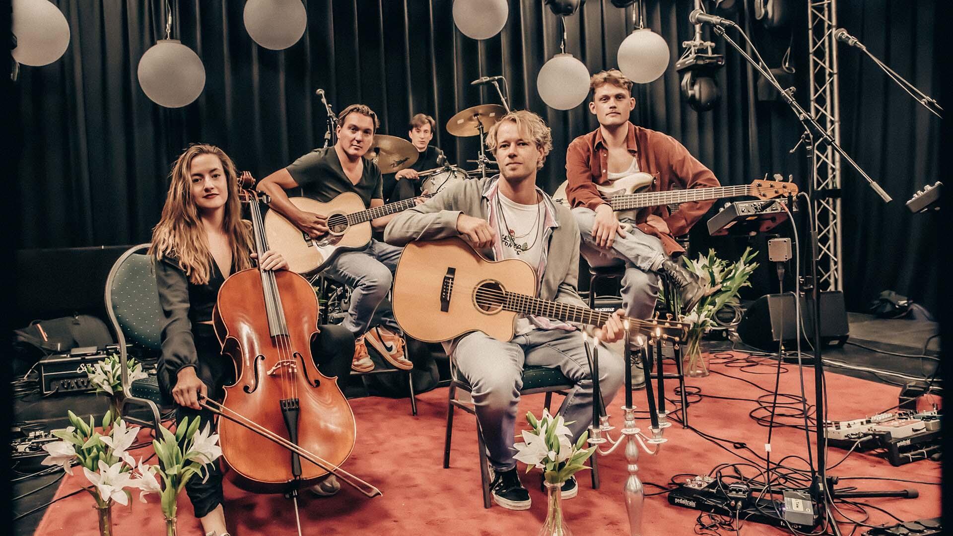 Vier bandleden met verschillende instrumenten in de hand
