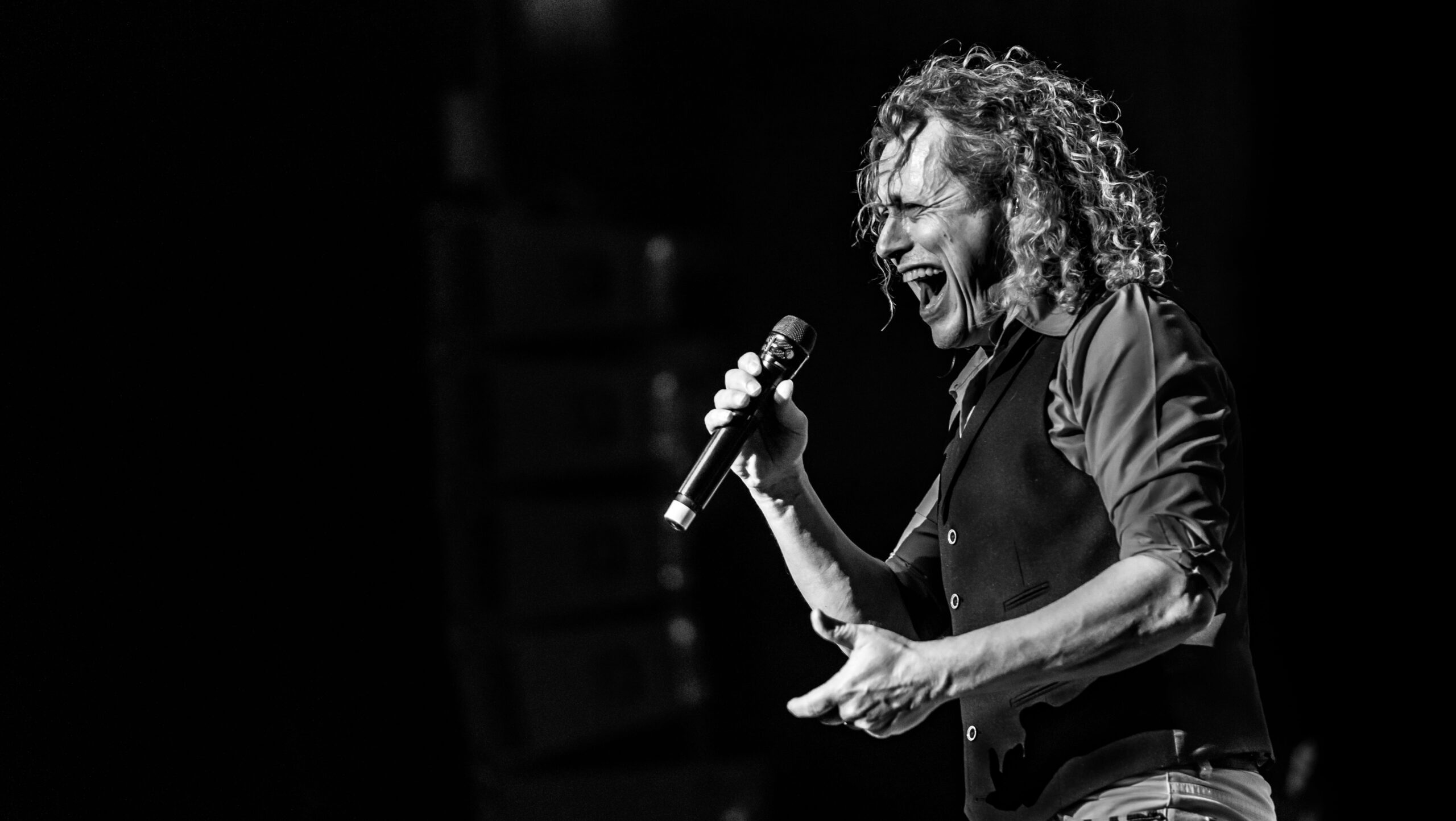 Zwart wit foto van een zanger die zingt in een microfoon