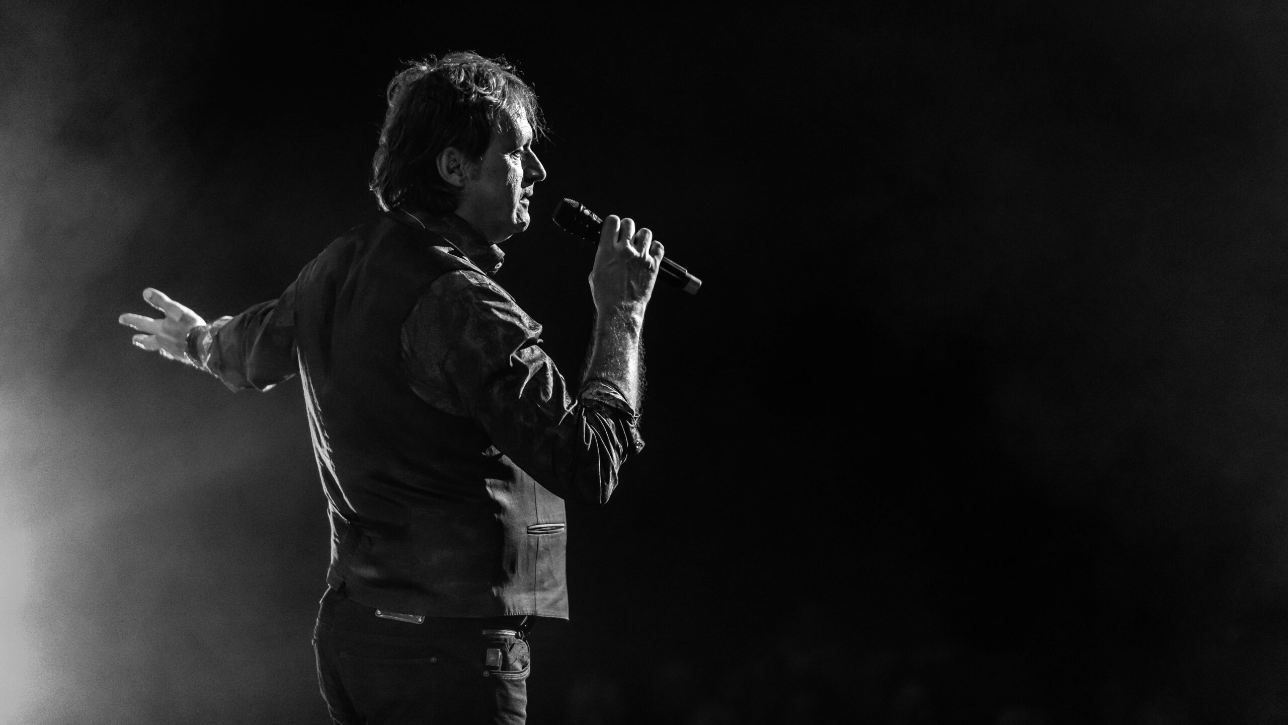 Zwart wit foto van een zanger die zingt in een microfoon