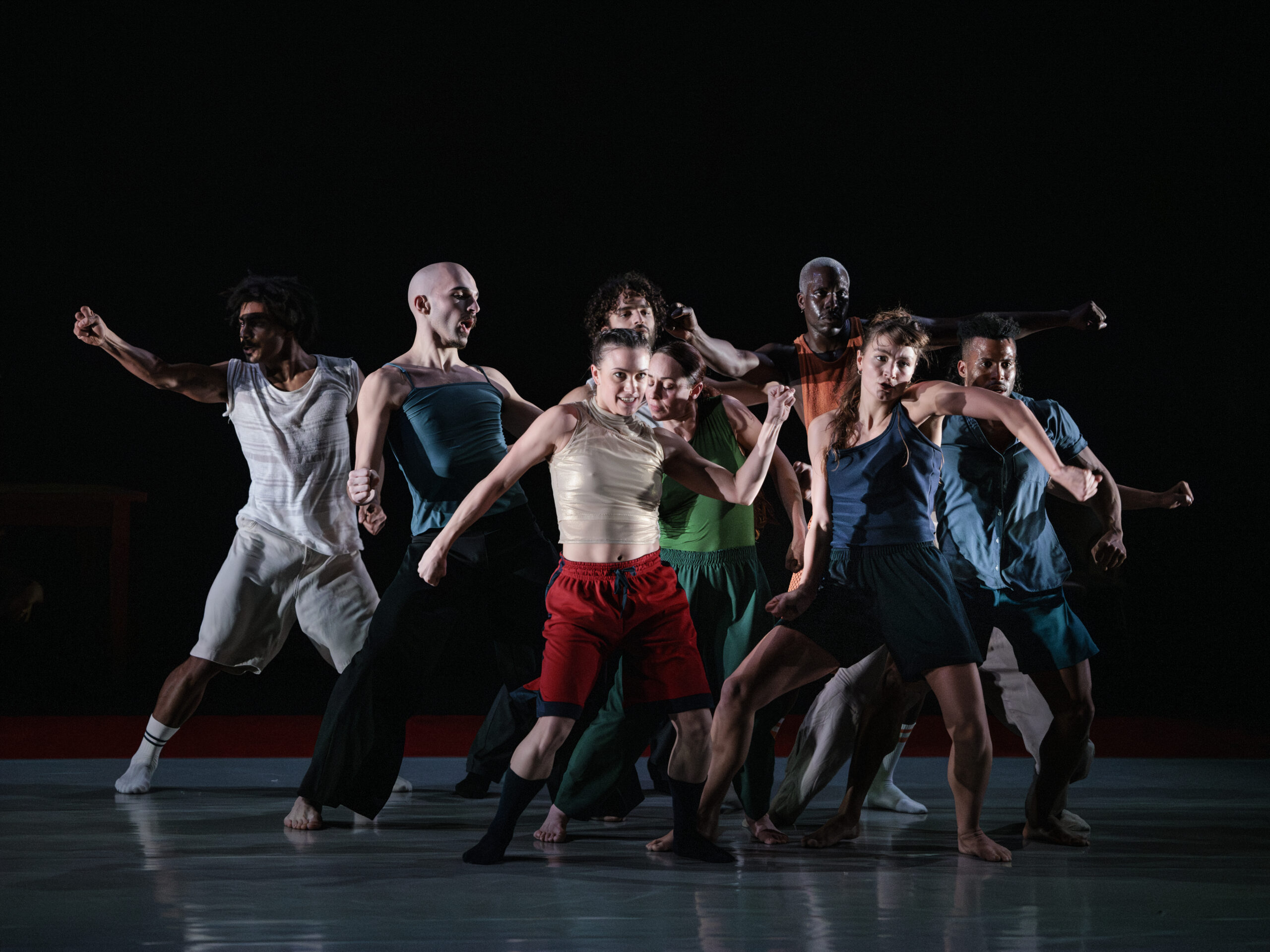 Een groep dansers staan bij elkaar op het podium