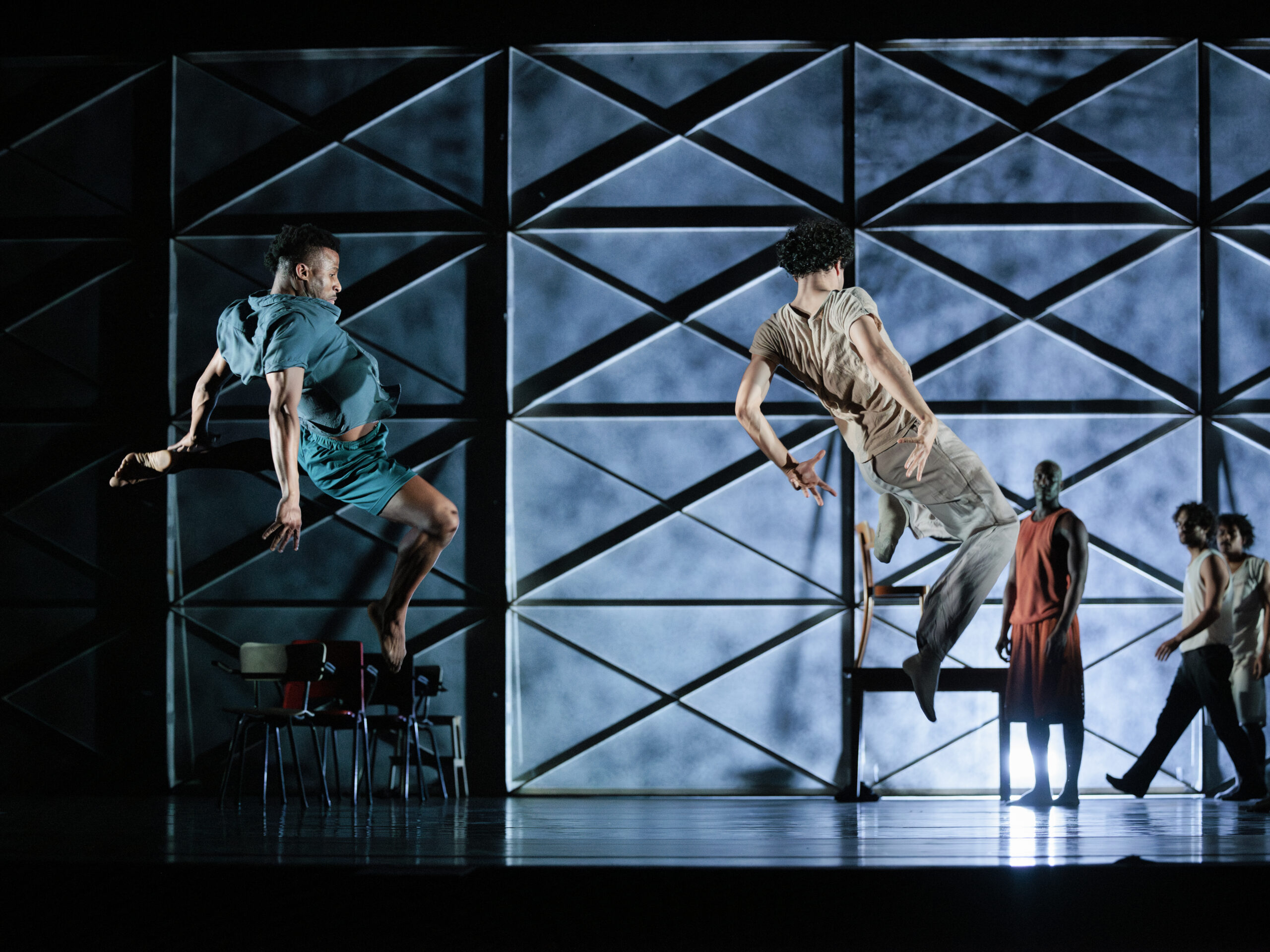 Twee dansers die synchroon in de lucht springen