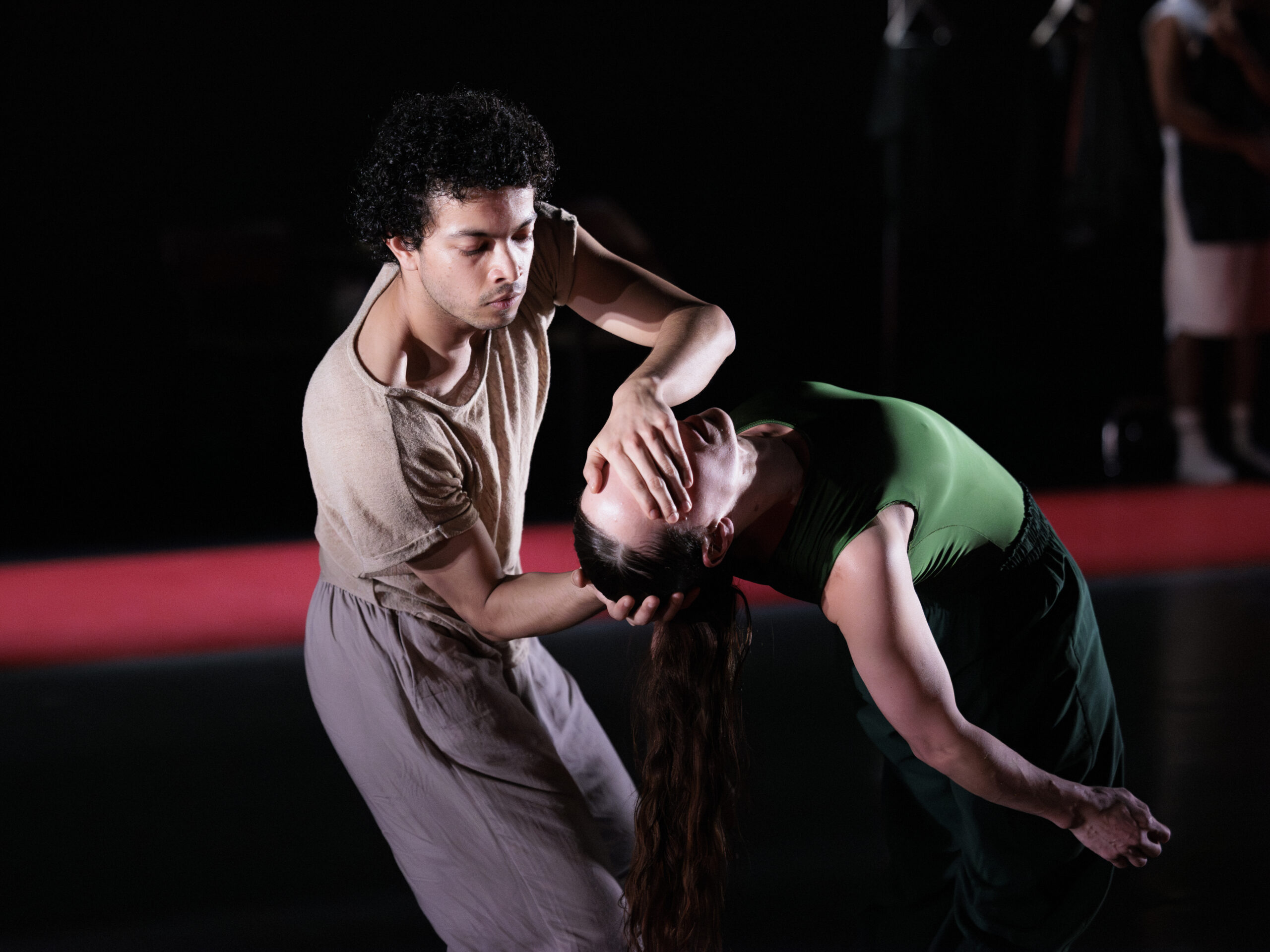 Twee dansers waarvan een danser het hoofd ondersteunt van de andere danser en de ogen toedekt