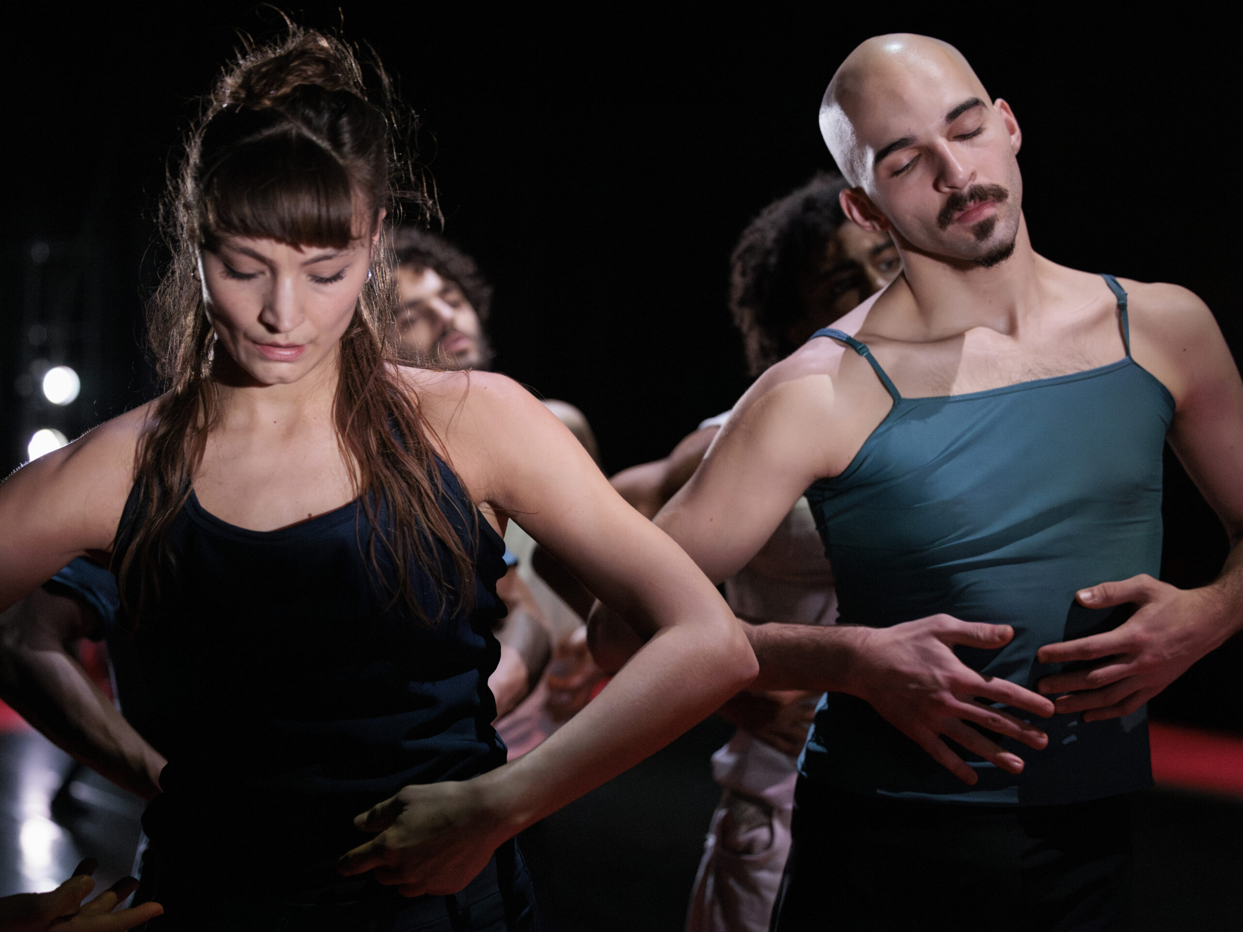 Twee dansers die zij aan zij staan en naar beneden kijken met de handen in heupen
