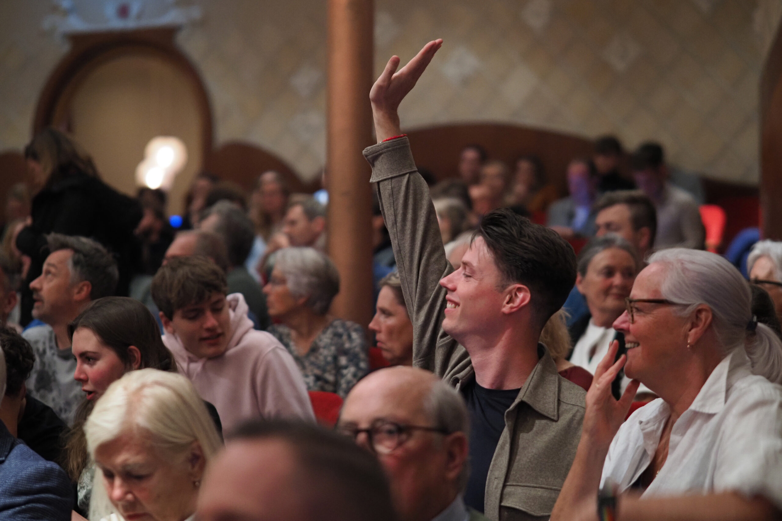 Een foto van het publiek net voordat de voorstelling in de Grote Zaal van de Schouwburg van start gaat