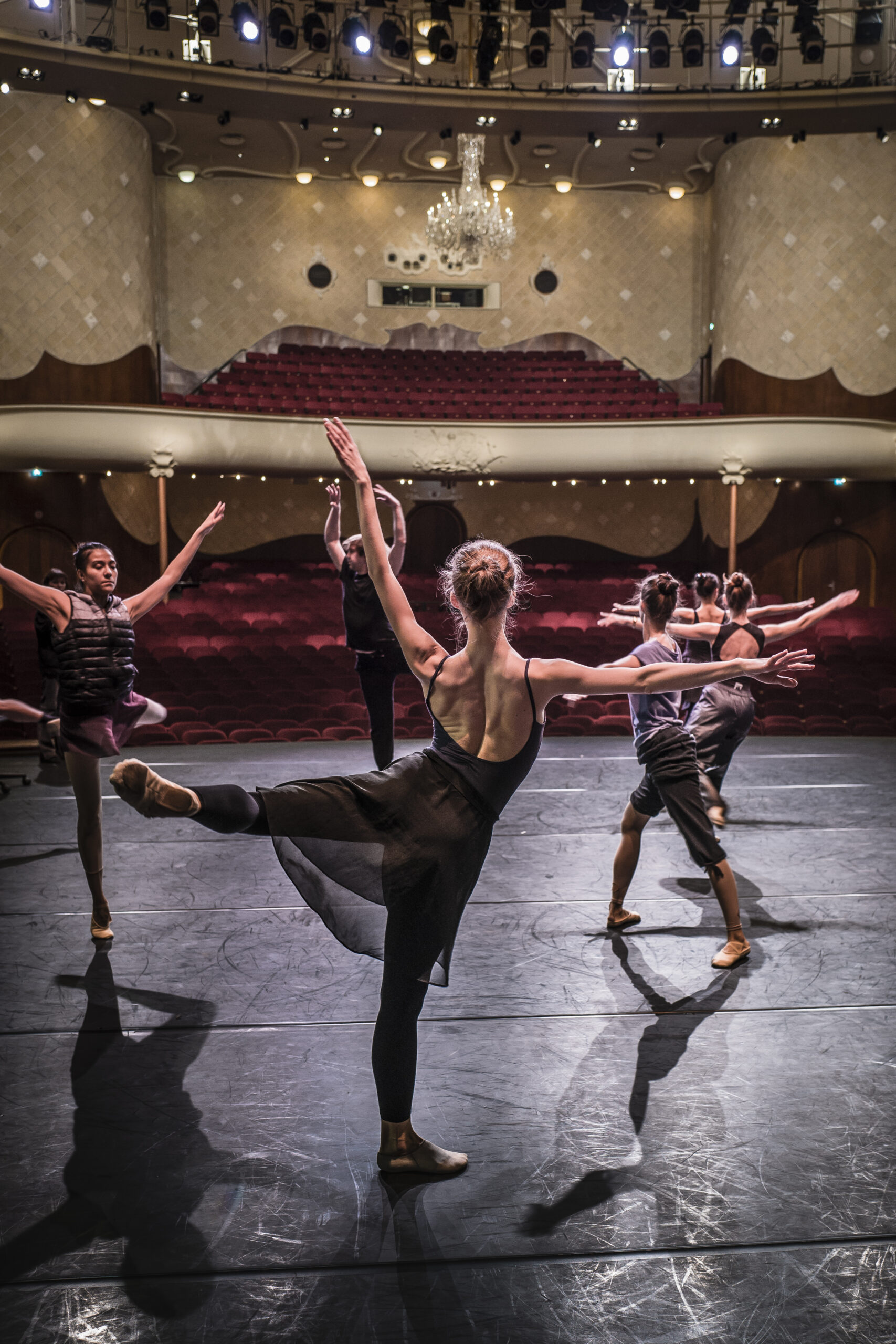 Ballerina's warmen zich op op het toneel van de Grote Zaal in de Schouwburg voordat de voorstelling begint