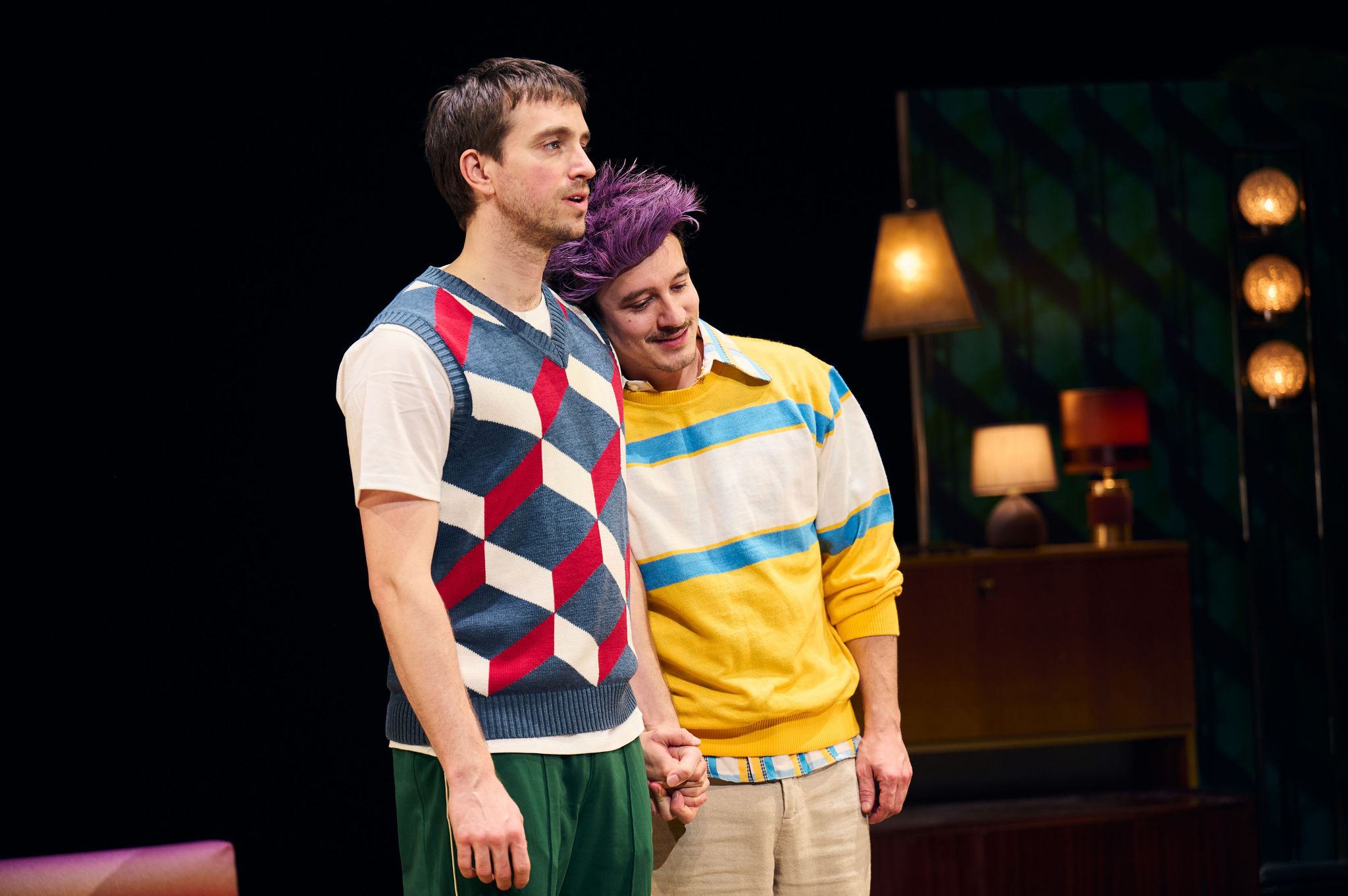Twee jongens met kleurrijke truien aan staan hand in hand