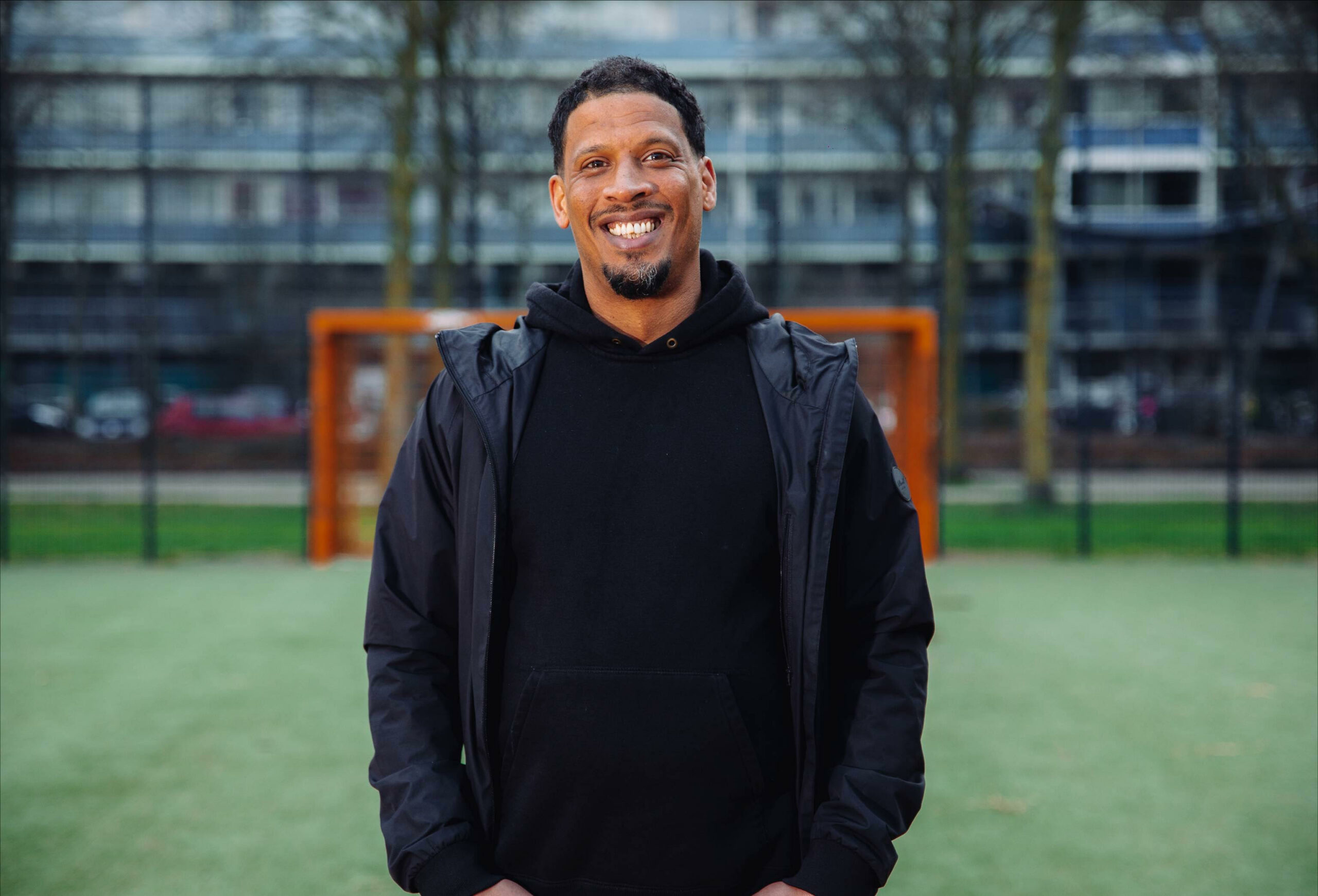 Foto van rapper Rico op een voetbalveld.