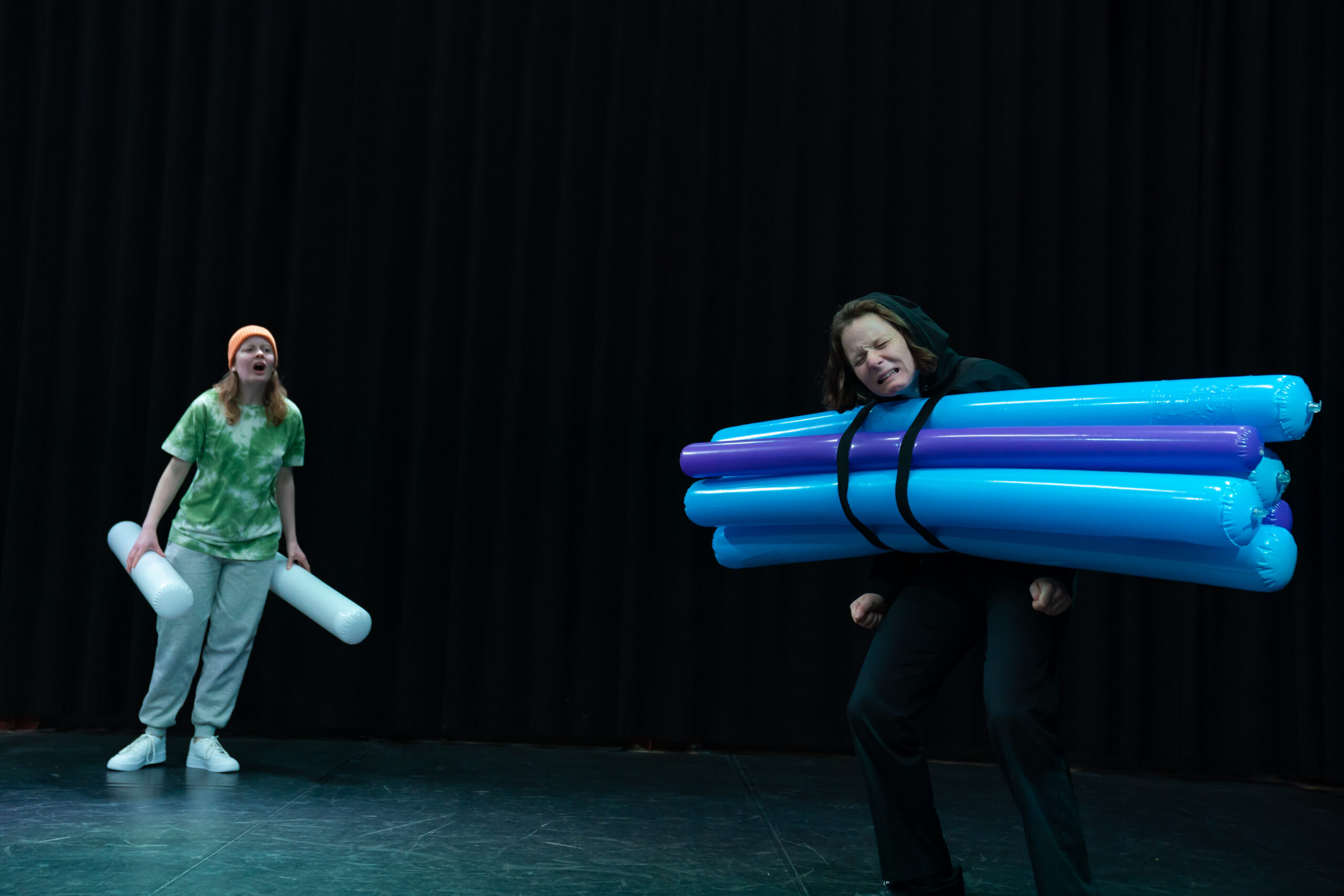 Twee vrouwen met lichtbuizen vast. Link heeft twee lichtbuizen vast en rechts heeft meerdere lichtbuizen aan haar vastgekleefd.