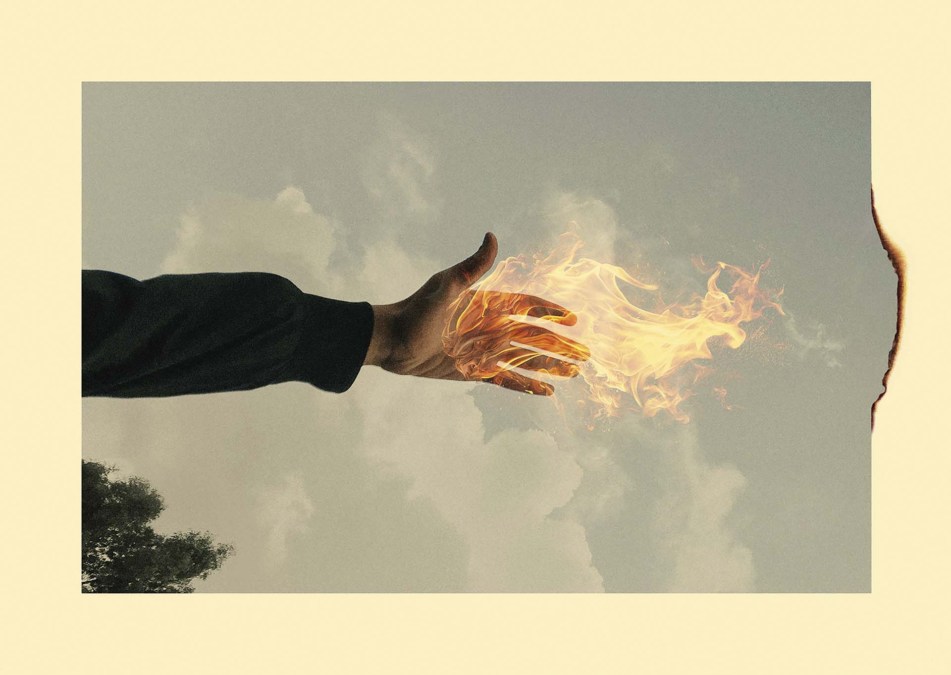 Een uitgestoken hand waar vlammen uit lijken te komen, tegen een bewolkte lucht met een gebrande rand aan de rechterzijde van het beeld.
