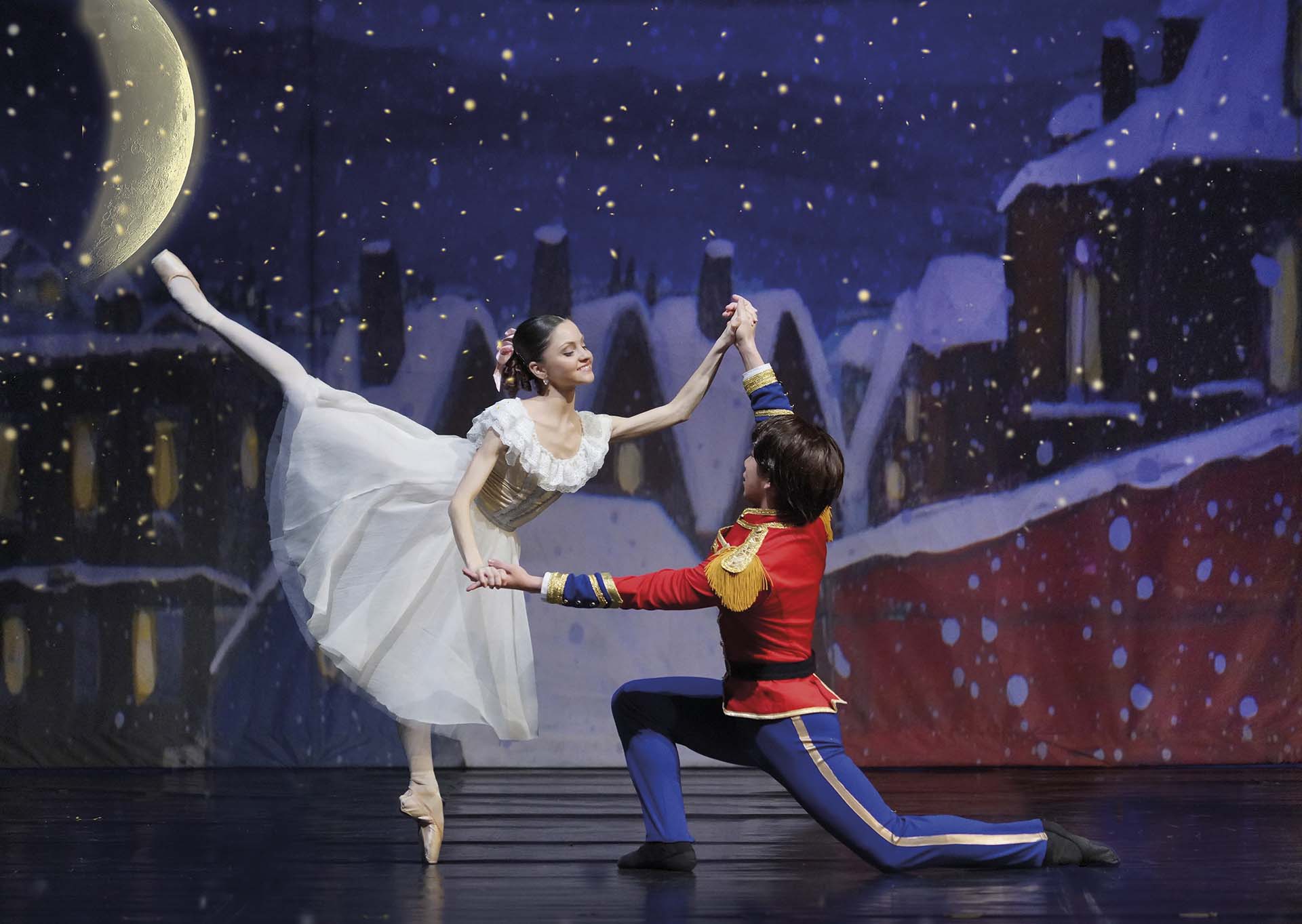 Balletdansers voeren een duet uit in een winters decor met maanlicht en sneeuwvlokken, uit De Notenkraker.
