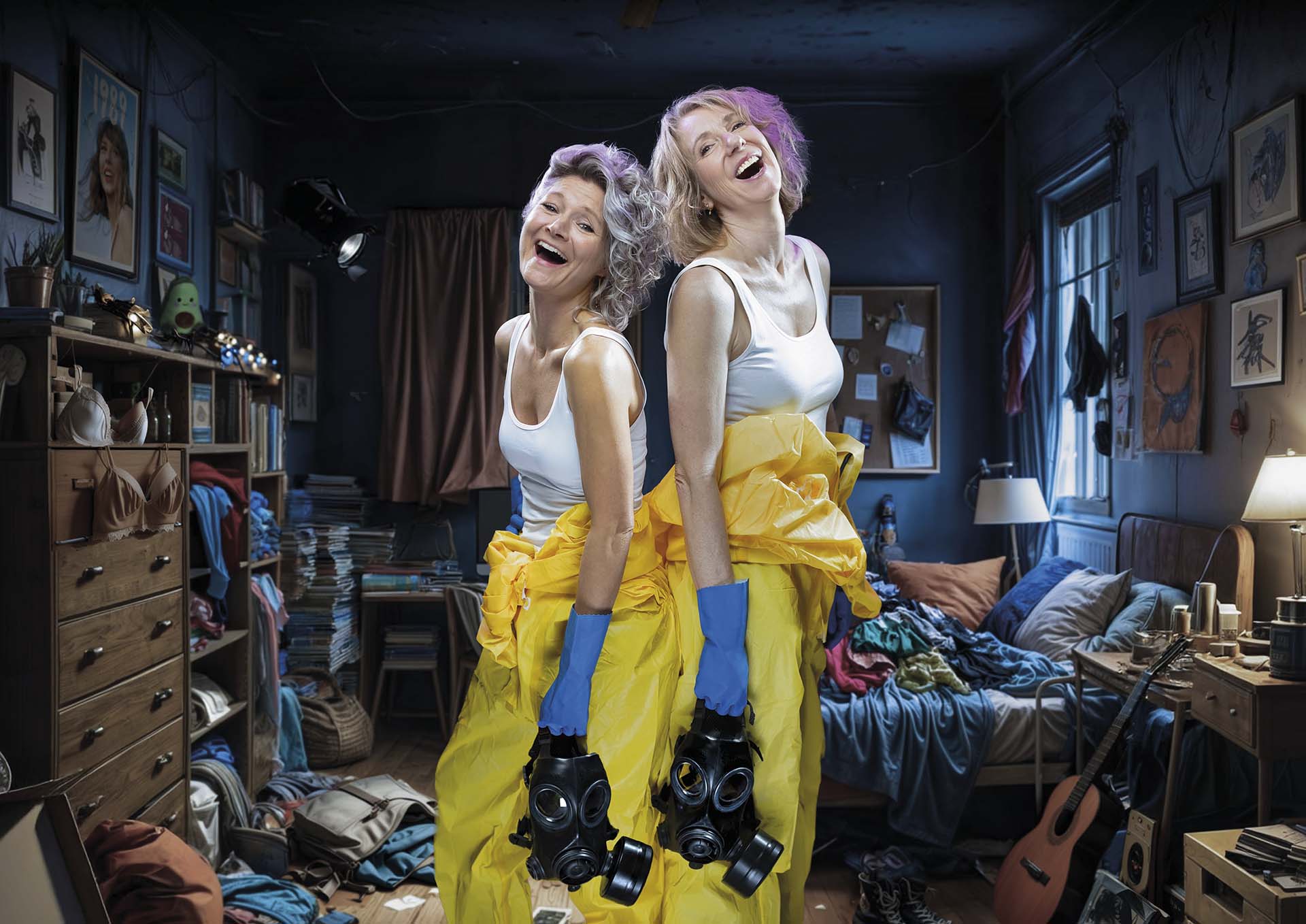 Twee vrouwen staan rug aan rug in een rommelige kamer, gekleed in witte tops en gele beschermpakken, terwijl ze lachend gasmaskers vasthouden