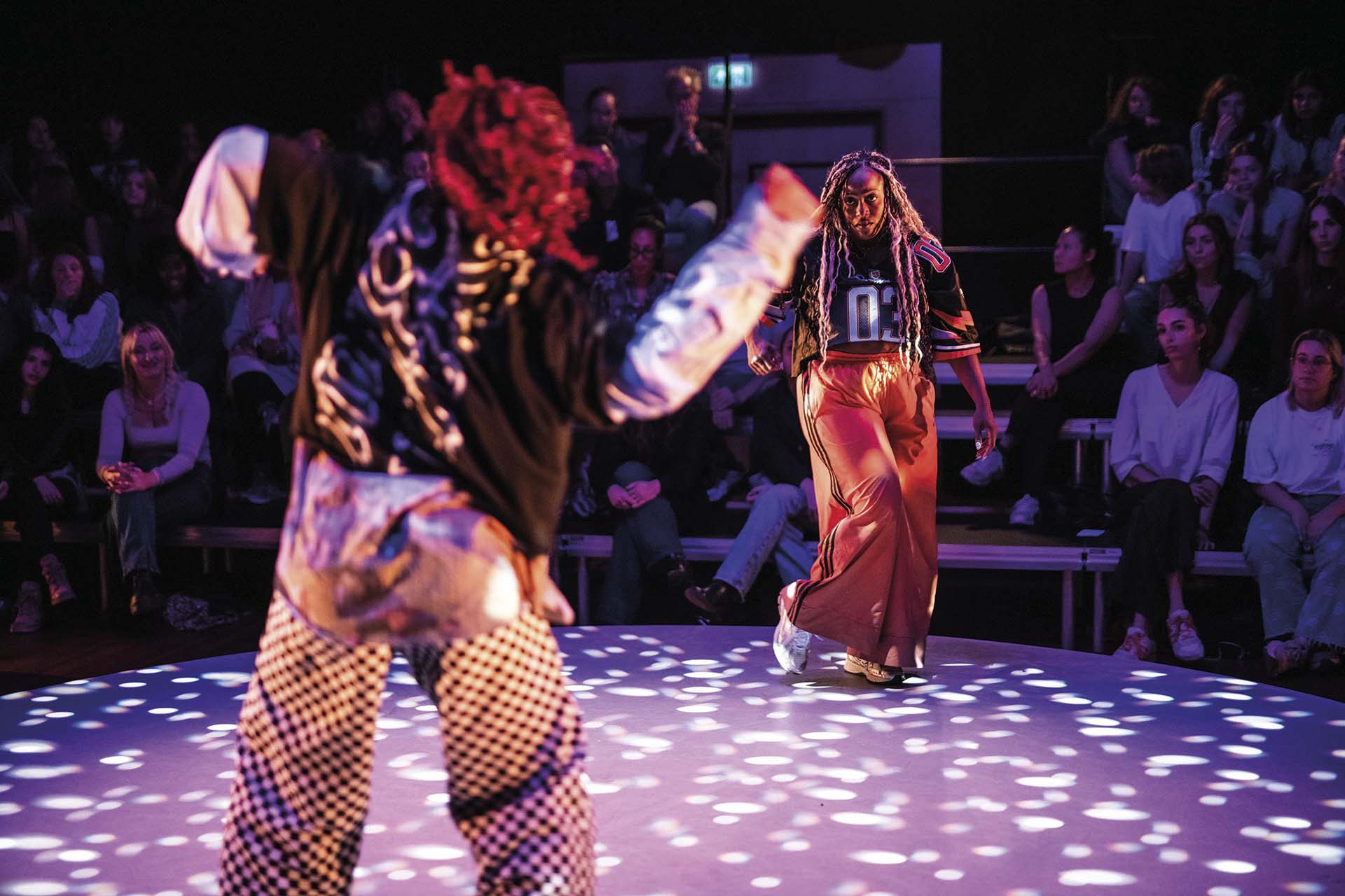 Danser beweegt energiek over podium met publiek rondom