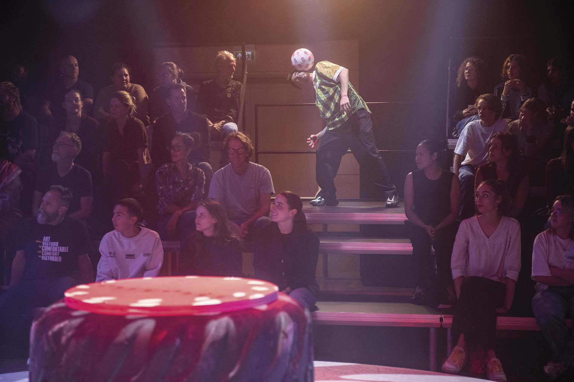 Danser balanceert voetbal op hoofd tussen publiek op tribune