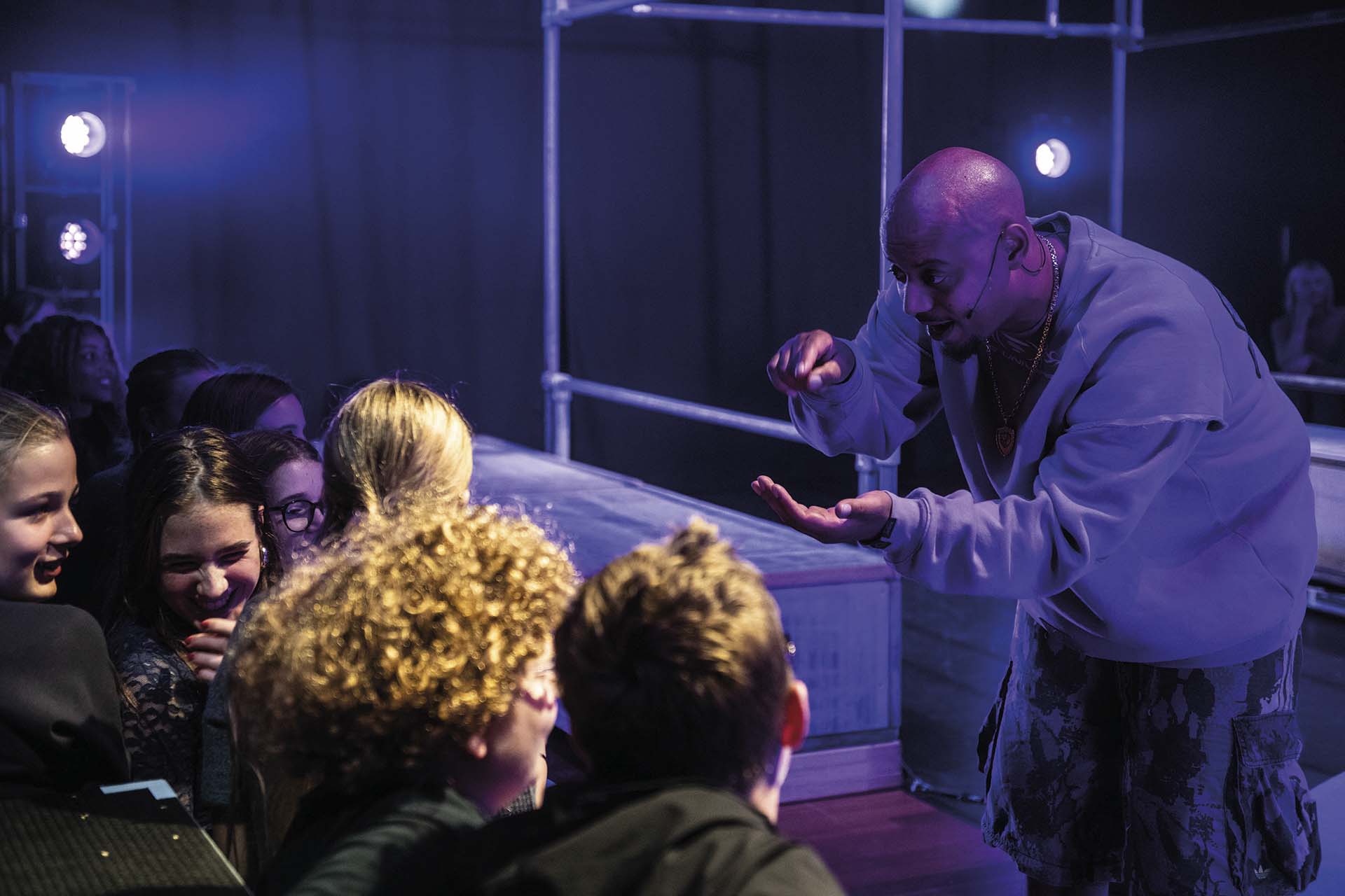 Performer speelt interactief met publiek aan rand van podium