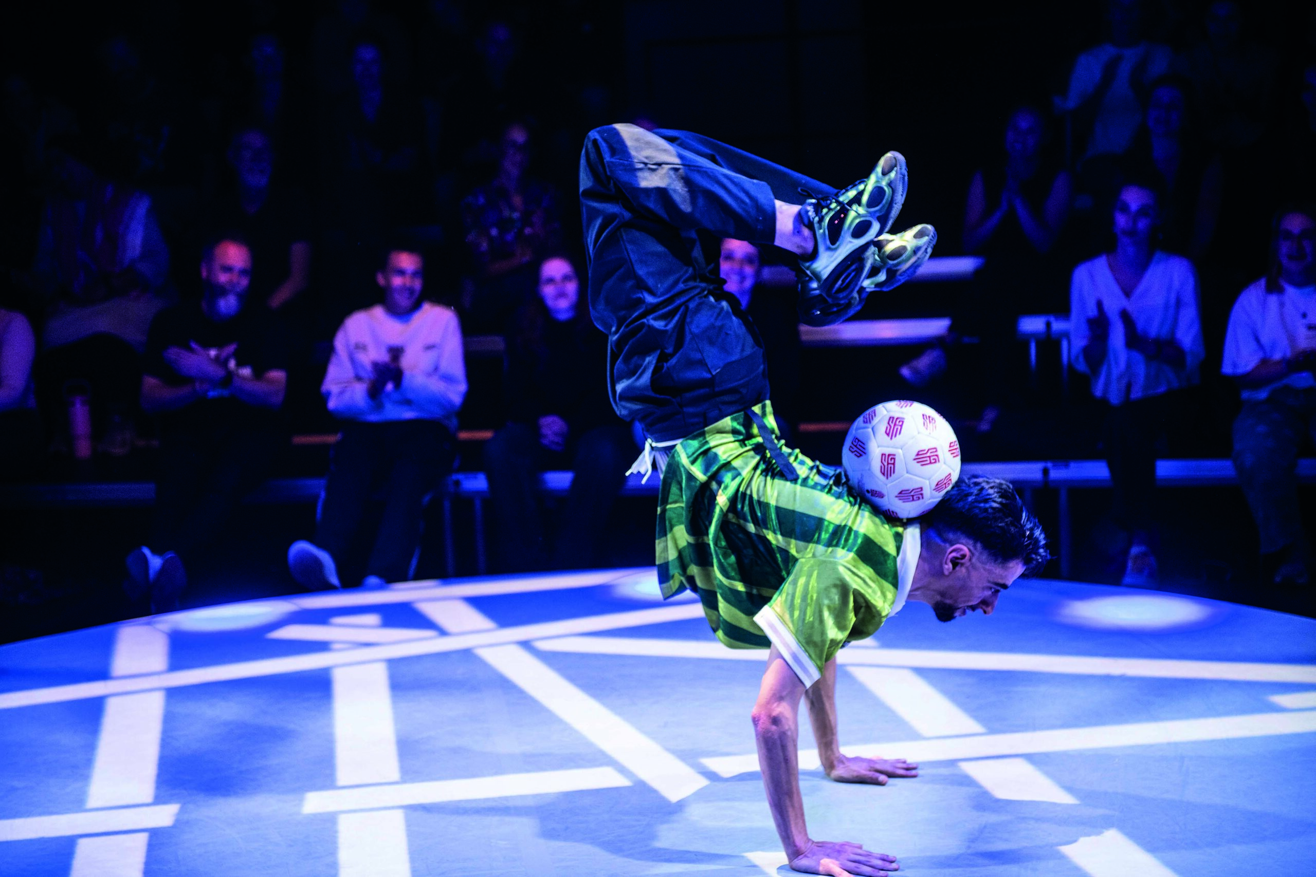 Breakdancer maakt freeze met voetbal op rug, publiek applaudisseert